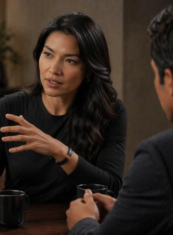 A coach explaining an idea across the table, wearing the Signature Cuff